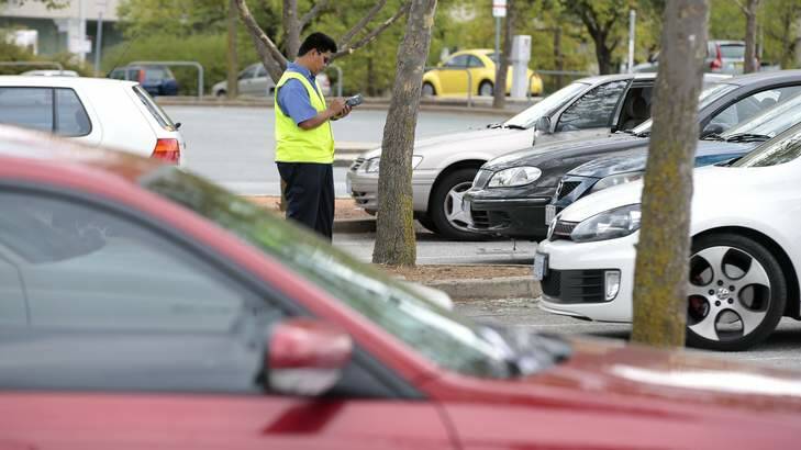 Drivers caught out: A parking inspector at work on London Circuit near New Acton.