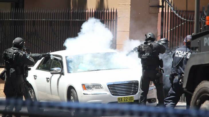 Police storm the car outside Parliament House. Photo: Peter Rae