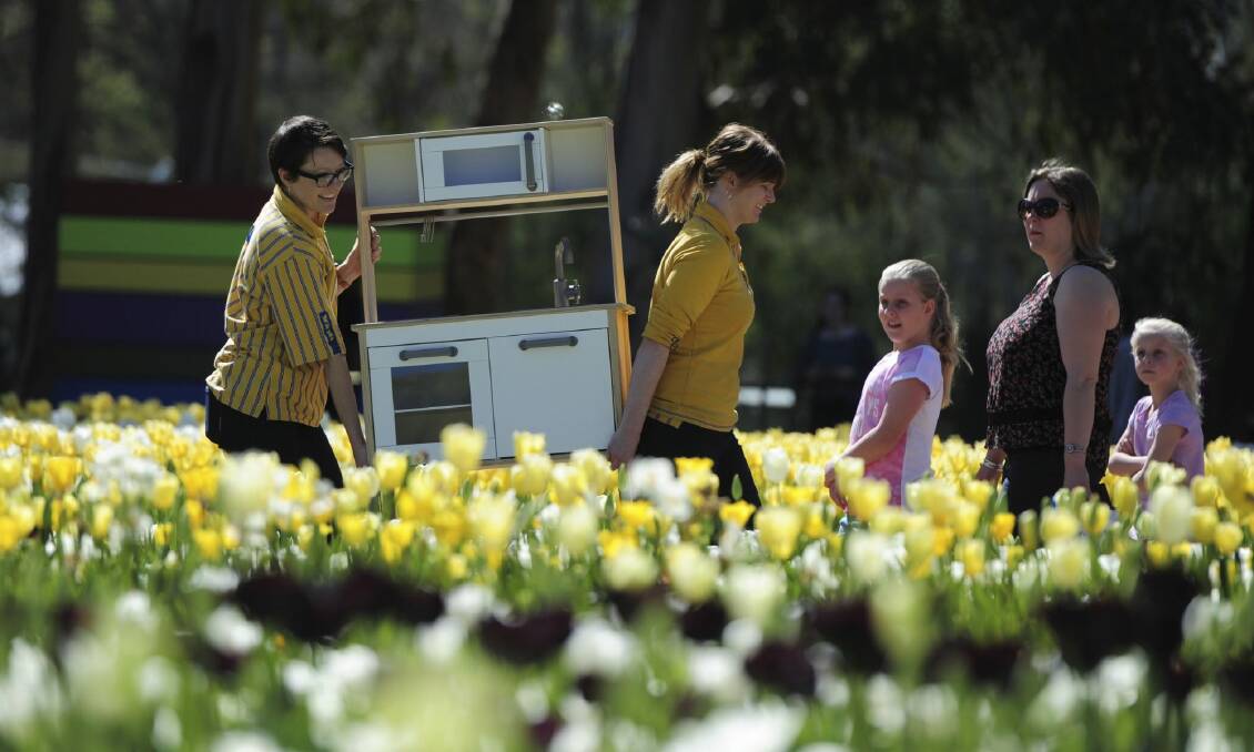 IKEA workers Rebecca Smith and Casey Gill "hide" a Duktig (children's kitchen) near their
Floriade display. Photo: Graham Tidy