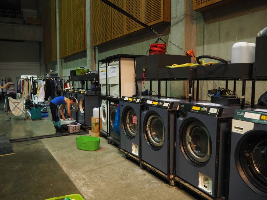 Industrial washing machines and dryers used for costumes and for personal clothing line the backstage area and travel with the tour. Photo: Clare Colley