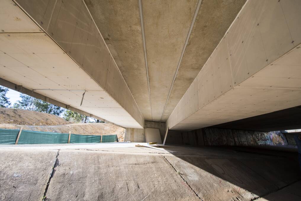 Two sets of cable trunking – enclosures used to protect electrical cables – fixed to the underside of a bridge on Flemington Road. The area between the two shows the bridge's regular height. Photo: Dion Georgopoulos