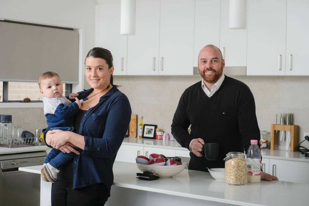Sophie Victory, Nick Paine, and five-month-old Oscar at home in Casey.  Nick, a real estate agent, says demand for stand-alone homes in Gungahlin remains high. Photo: Sitthixay Ditthavong