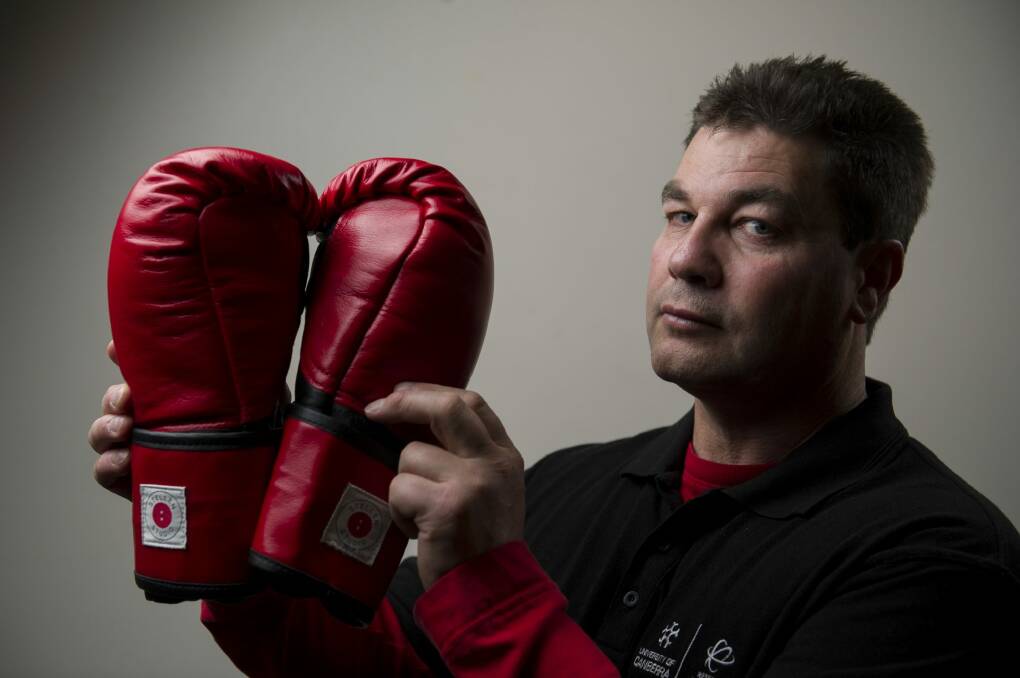PhD student Paul Perkins has designed boxing gloves which reduce the impact to the person receiving the blow as part of a process to try to increase participation in boxing. Photo: Jay Cronan