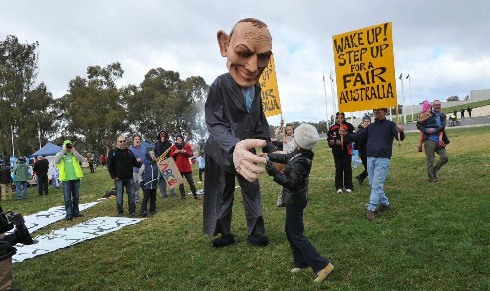 A large puppet in the likeness of Prime Minister Tony Abbott, complete with pants on fire, was a major draw card at the 'bust the budget' rally. Photo: Graham Tidy