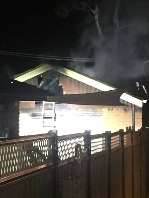 Smoke rises from a detached garage after a fire sparked by an unattended heater in Kambah. Photo: Emergency Services Agency