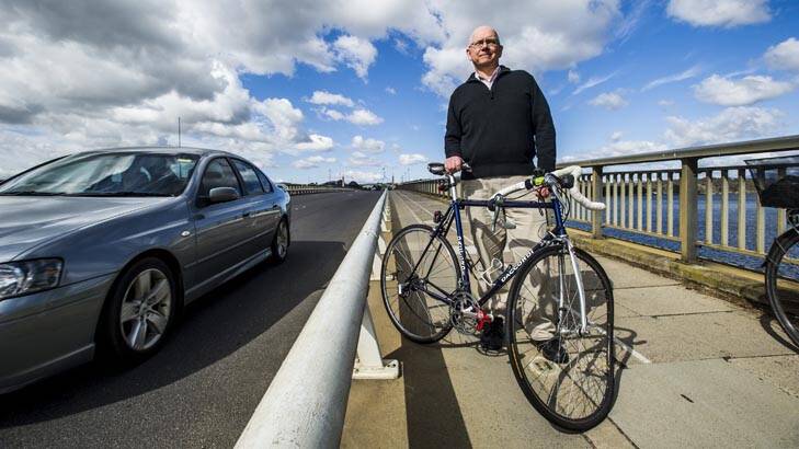 David Mann with his bent bike near where he fell over the railing into the path of traffic on the Commonwealth Avenue bridge. Photo: Rohan Thomson