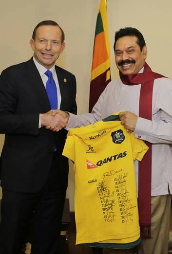 Prime Minister Tony Abbott gives Sri Lanka's President Mahinda Rajapaksa a signed Australian Rugby Union jersey in Colombo. Photo: Reuters