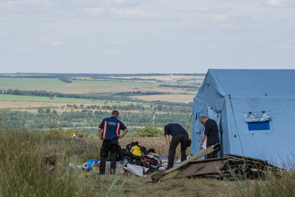 Inspectors from the Dutch government examine items at the Malaysia Airlines flight MH17 crash site. Photo: Brendan Hoffman