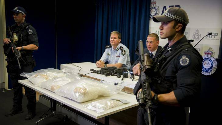 Acting Commander Paul Shakeshaft and Detective Sergeant Shane Scott address the media while armed police guard the drugs. Photo: Jay Cronan