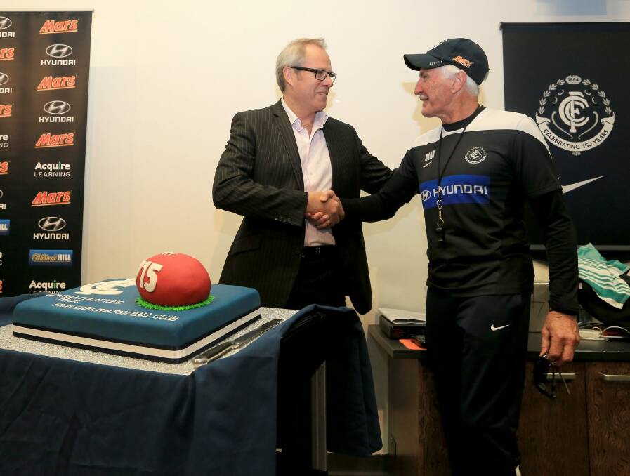 Mick Malthouse is presented with a cake ahead of his record-breaking 715th game as coach. Photo: Wayne Taylor