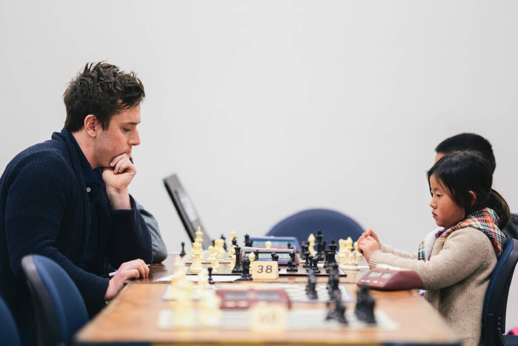 Labor MLA Michael Pettersson takes on Garran primary school student Hannah Ni in the ANU Open Chess Tournament on Sunday. Photo: Rohan Thomson