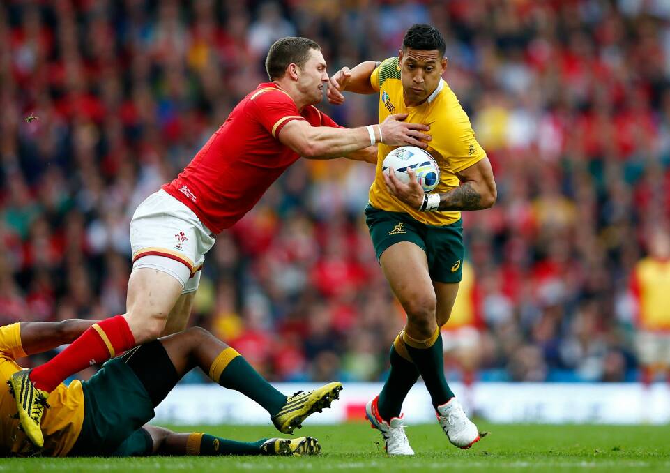 Australia's Israel Folau tries to make a break as he is tackled by George North. Photo: Shaun Botterill