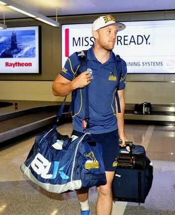 Brumbies player Jesse Mogg collects his luggage. Photo: Melissa Adams