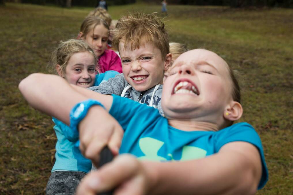 Emily Holdom, 9, Jay Holdom, 10, and Sophie Cahill, 10, in the tug-of-war at an olden day games workshop at Tidbinbilla. Photo: Matt Bedford
