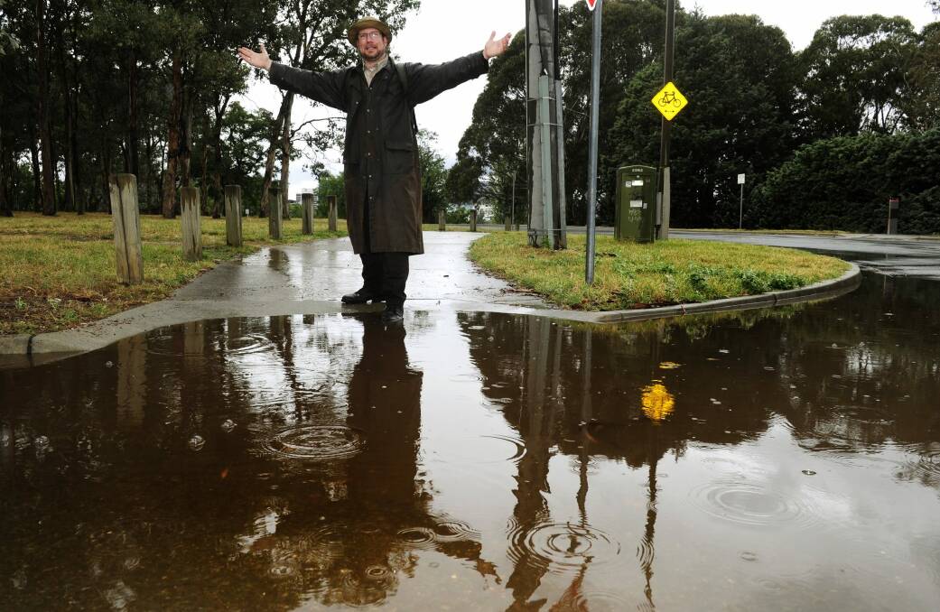 Tourist Andrew Platt was prepared for Canberra's wet weather conditions on Monday. Photo: Melissa Adams 