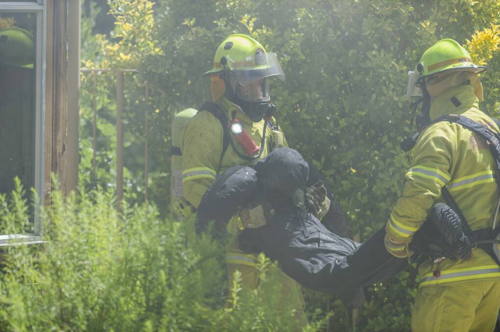 Firefighters carry a dummy out of the house. Photo: Jamila Toderas