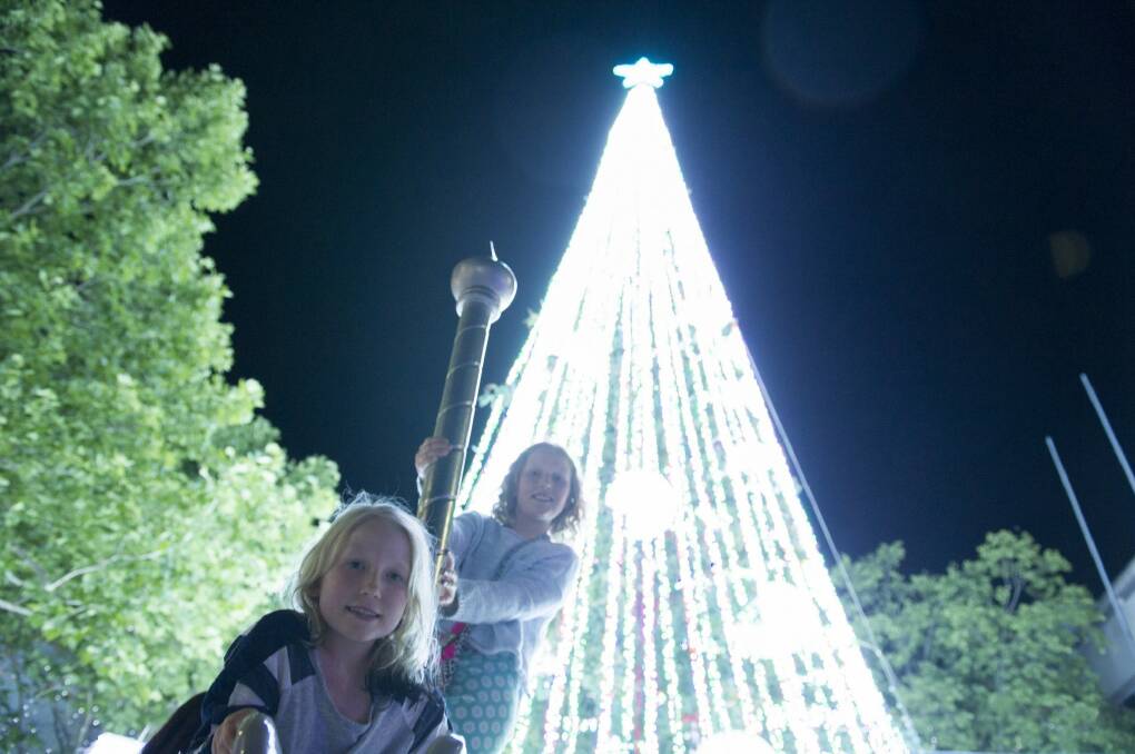 Edi Lupton, 9, and Cat Lupton 11 beneath the record-breaking light-covered Christmas tree. Photo: Jay Cronan