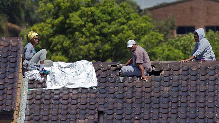 Three detainees on the roof at Villawood on Monday. Photo: Wolter Peeters