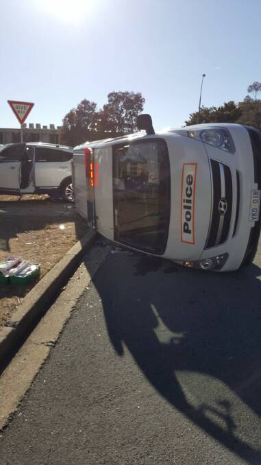 A police van rests on its side after a crash in Phillip on Wednesday morning. Photo: Supplied