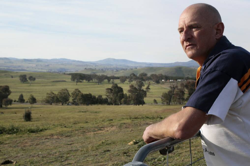Uriarra resident Michael Friedrich looks out at the fire abatement paddock that surrounds the township. Photo: Jeffrey Chan