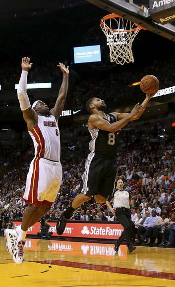 Developing: Patty Mills shoots despite the efforts of LeBron James. Photo: Getty Images