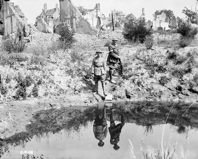 Soldiers at Ypres reflected in a shell crater lake.