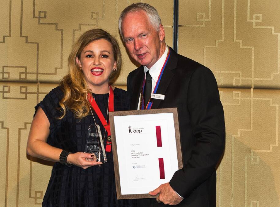 Canberra wedding photographer Kelly Tunney accepting her award from Ross Eason, national president of the Australian Institute of Professional Photographers. Photo: Craig Wetjen