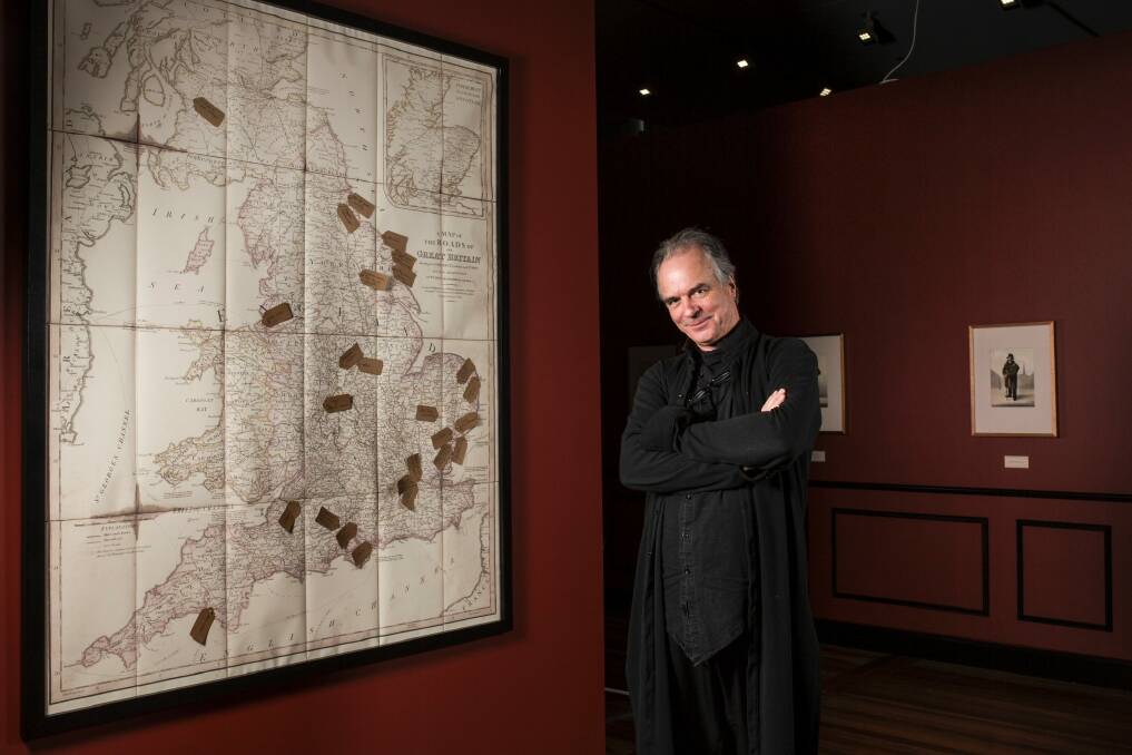 Exhibition curator David Hansen with a map showing where the artist painted many of his subjects. Photo: Jamila Toderas