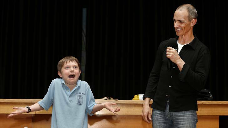 Ainslie School year 2 student Taj Whitney-Nash helps author Andy Griffiths demonstrate what happens when you shrug your shoulders while making an evil laugh. Photo: Jeffrey Chan