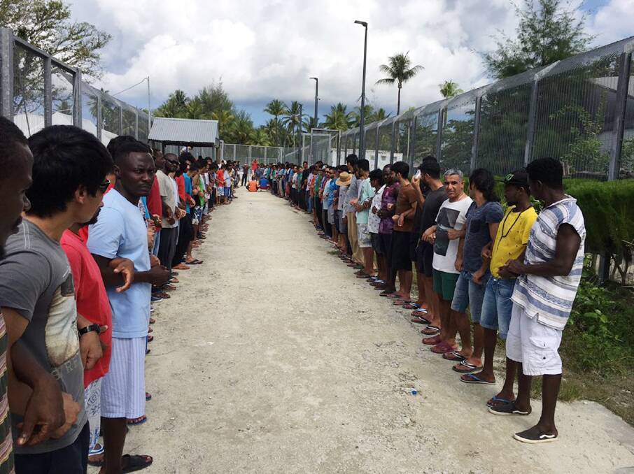 Refugees at Manus Island detention centre link hands in solidarity before the centre's closure this week.