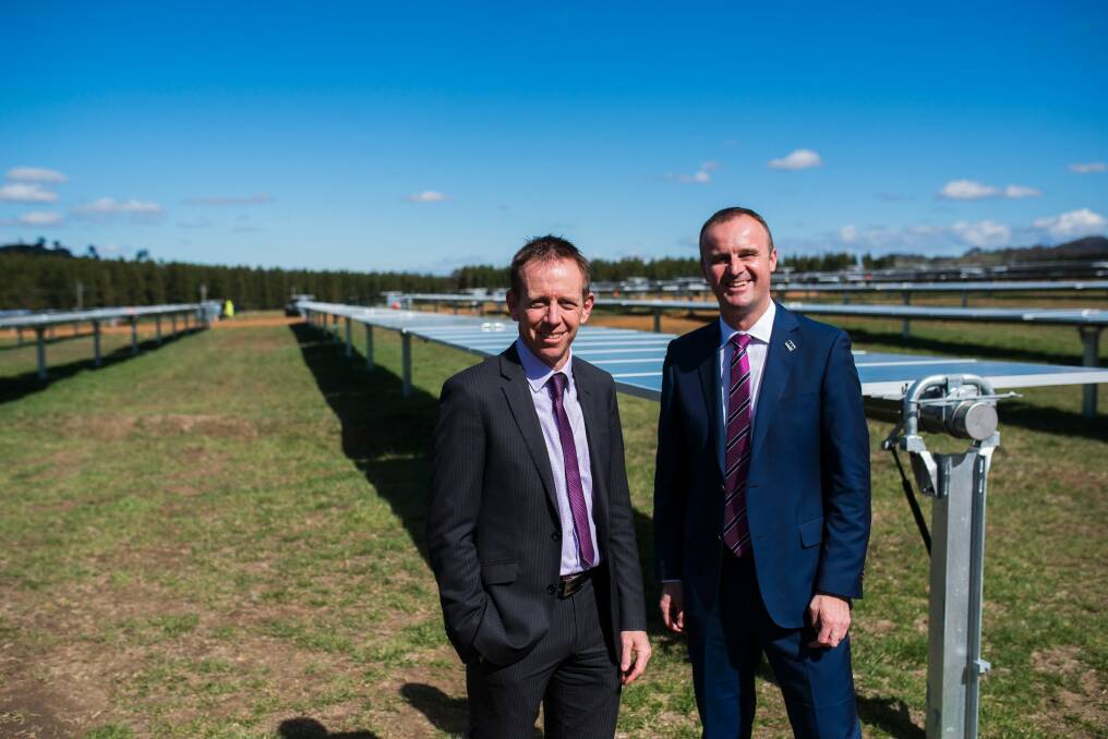 Ministers Shane Rattenbury and Andrew Barr at the Mugga lane solar farm in October 2016: Renewables scheme to cost each household about $144 a year in 2020, then fall away till Canberrans are making money on the deal. Photo: Rohan Thomson