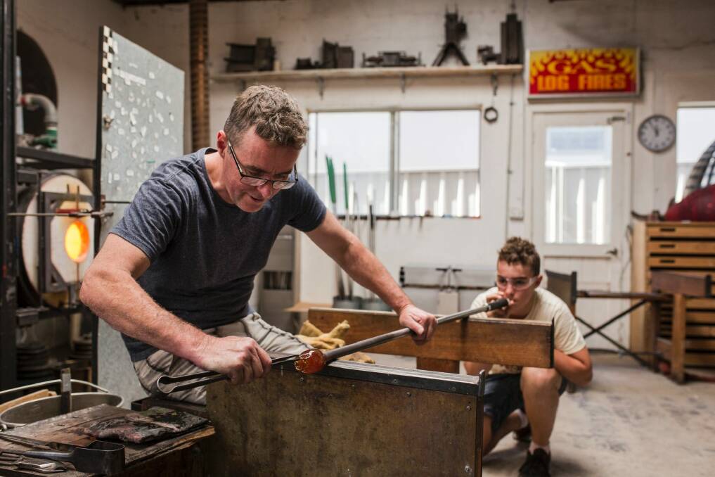 Glass artist Matt Curtis teaches his son Hugo Curtis his craft at Curtis Glass Art Studio. Photo: Jamila Toderas