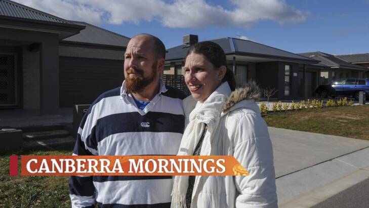 Ian and Katrina Hughes outside their home in Googong, where prices are close to half what they are in the ACT. Photo: Graham Tidy