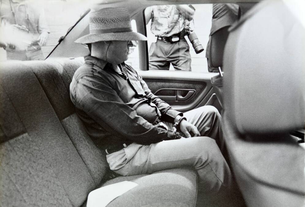 Eastman, handcuffed, sits alone in the rear of a police car shortly after his arrest in December 1992.  Photo: Graham Tidy