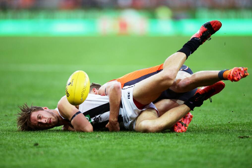 Grounded: Magpie Tom Phillips is tackled by returning Giant Lachie Whitfield. Photo: Getty Images