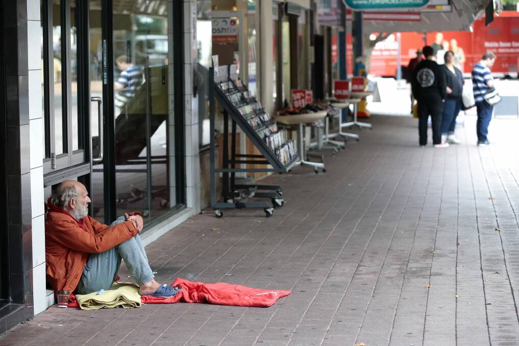 A man seeking help from passers-by in Garema Place. Photo: Jeffrey Chan
