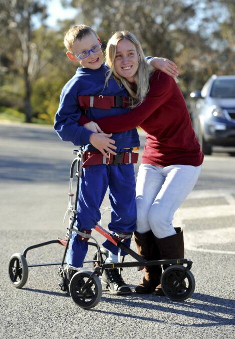 10-year-old Dylan Schwarz of Wanniassa, who has cerebral palsy, with his mum Rebecca and the new Hart walker. Photo: Graham Tidy