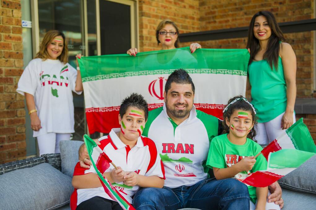 Self-confessed football fanatic Ali Parvizi (centre), of Bonython, will cheer on Iran at Friday's AFC Asian Cup quarter-final at Canberra Stadium. He will be joined by his children Navid, 8, (left), and Anita, 7, (right), as well as (back, from left) family members Mehri Roses-Parvizi, Maryam Parvizi and Danielle Parvizi.
 Photo: Jamila Toderas