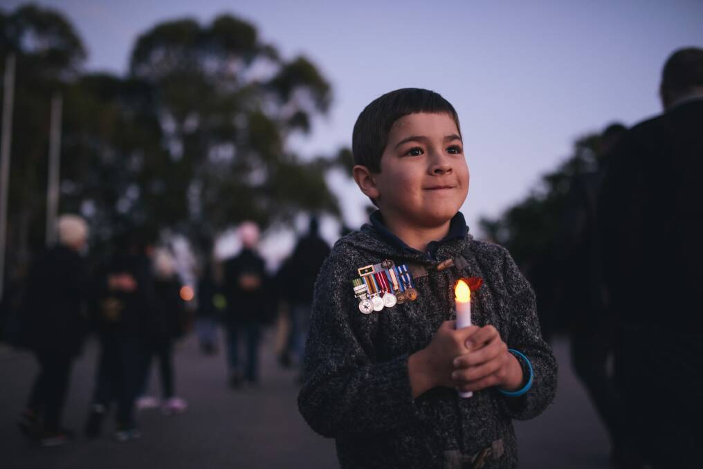 Luke Piontek, 6, wearing the medals of his uncle, Luke Worsley, who died in Afghanistan in 2007, at the Anzac Day Dawn Service. Photo: Rohan Thomson