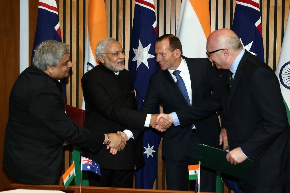Indian Prime Minister Narendra Modi shakes hand with then prime minister Tony Abbott and Attorney-General George Brandis during his 2014 visit to Australia. Photo: Alex Ellinghausen