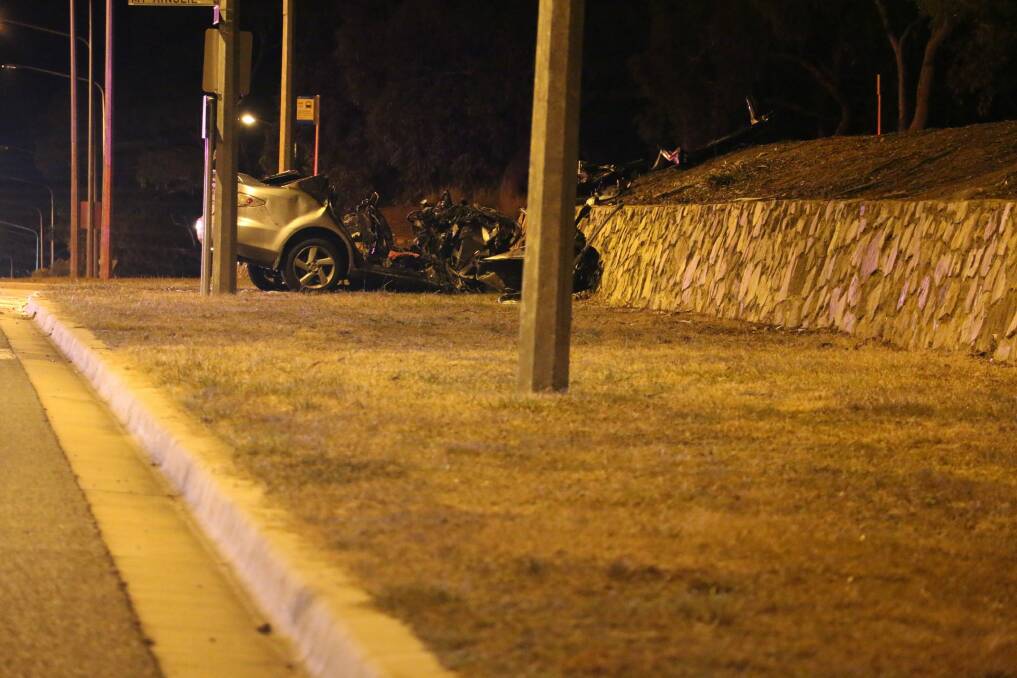 The car crashed into a rock retaining wall.