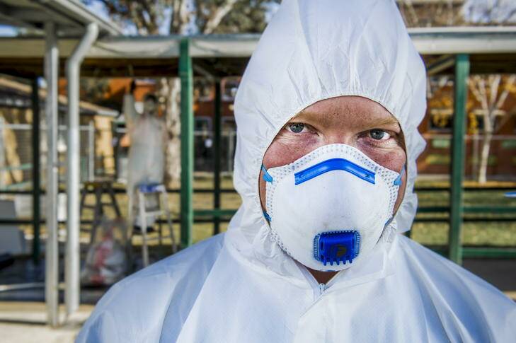 Jamie Carpenter (front), and Garry Harriden, removing asbestos from a local site. Photo: Rohan Thomson