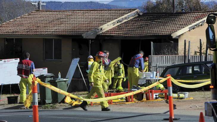GUTTED: Firemen attend the house fire in Kambah over which a woman has been charged. Photo: Graham Tidy