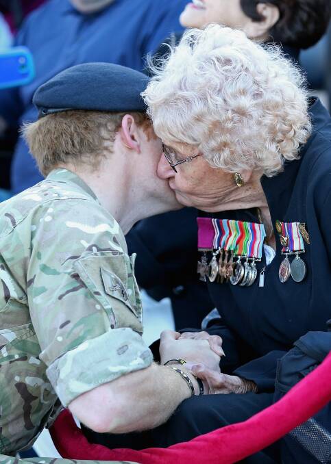 Prince Harry meets Daphne Dunne, who is wearing her husband's Victoria Cross. Photo: Getty Images
