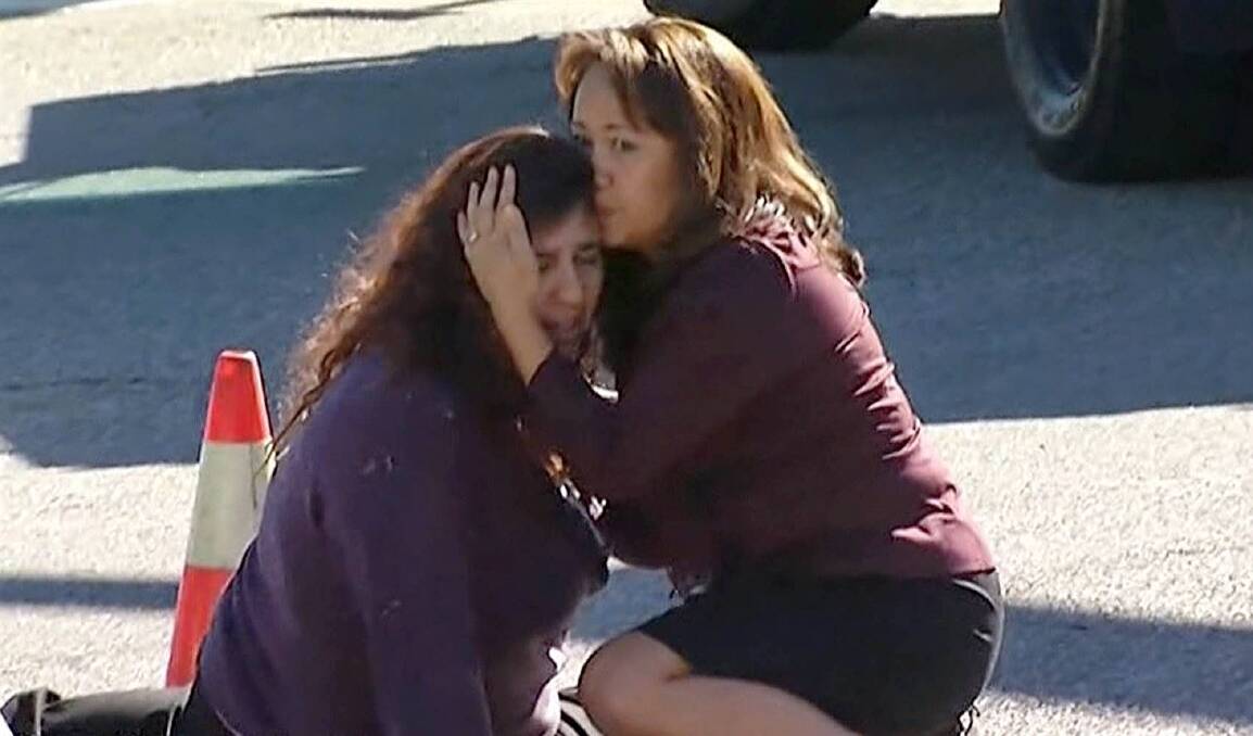 Two women comfort each other near the scene of a shooting in San Bernardino, California, on December 2, 2015. Photo: AP