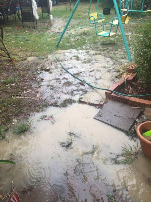 Floodwaters washing from a cleared Mr Fluffy block in Goulburn Street, Macquarie, against the house and into the yard of neighbours Greg and Melissa Wilson, who are worried about contamination. Photo: Greg Wilson