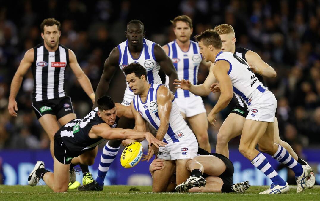 Scott Pendlebury of the Pies and Daniel Wells of the Roos compete for the ball. Photo: Getty Images
