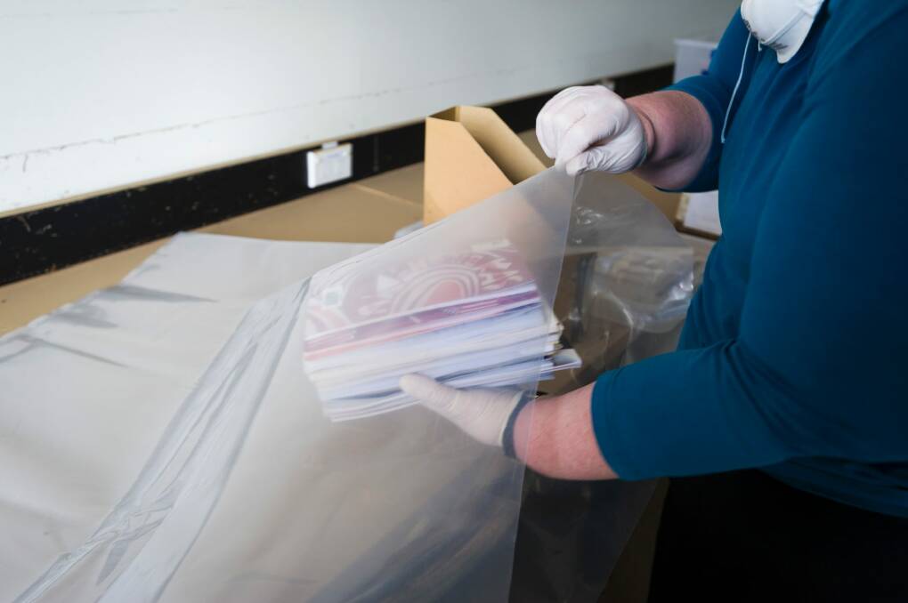  Sarah Lethbridge senior archivist demonstrates how to package the books for freezing.  Photo: Dion Georgopoulos
