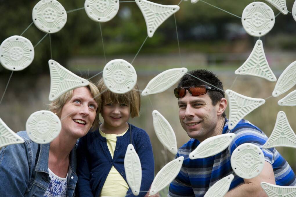 Michael and Jenny Grimm of Wollongong show their daughter Eva, 3, some of the sculptures that are on show for the Queanbeyan River Festival. Photo: Jay Cronan