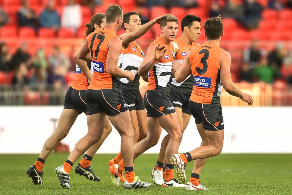Cause for celebration: GWS players get around Jacob Hopper after he kicked a goal in the second term. Photo: Getty Images